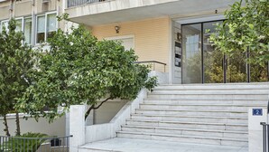 A building entrance with a set of marble stairs leading up to a door marked with the number 2.
