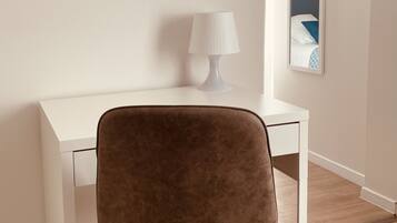 A modern room with a white desk, a brown chair, a white lamp, and a mirror on the wall.