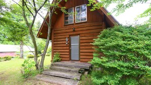 A wooden cabin with a front porch and a door with a window above it. - Kizin (Takamori)