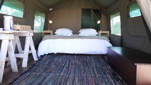 A tent with a bed, a desk, and a lamp. - OUT OF Nature Country Lodge (Windhoek)