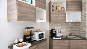 A modern kitchen with wooden cabinets, a microwave, a coffee maker, and a sink. - B&B Relax in Pompei (Pompei)