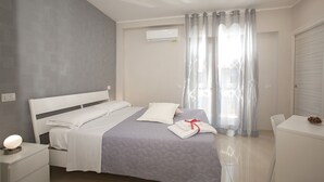 A modern hotel room with a bed, bedside tables, a desk, and a chair. - B&B Relax in Pompei (Pompei)