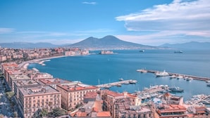 A coastal cityscape with a marina, buildings, and a mountain in the background. - B&B Relax in Pompei (Pompei)