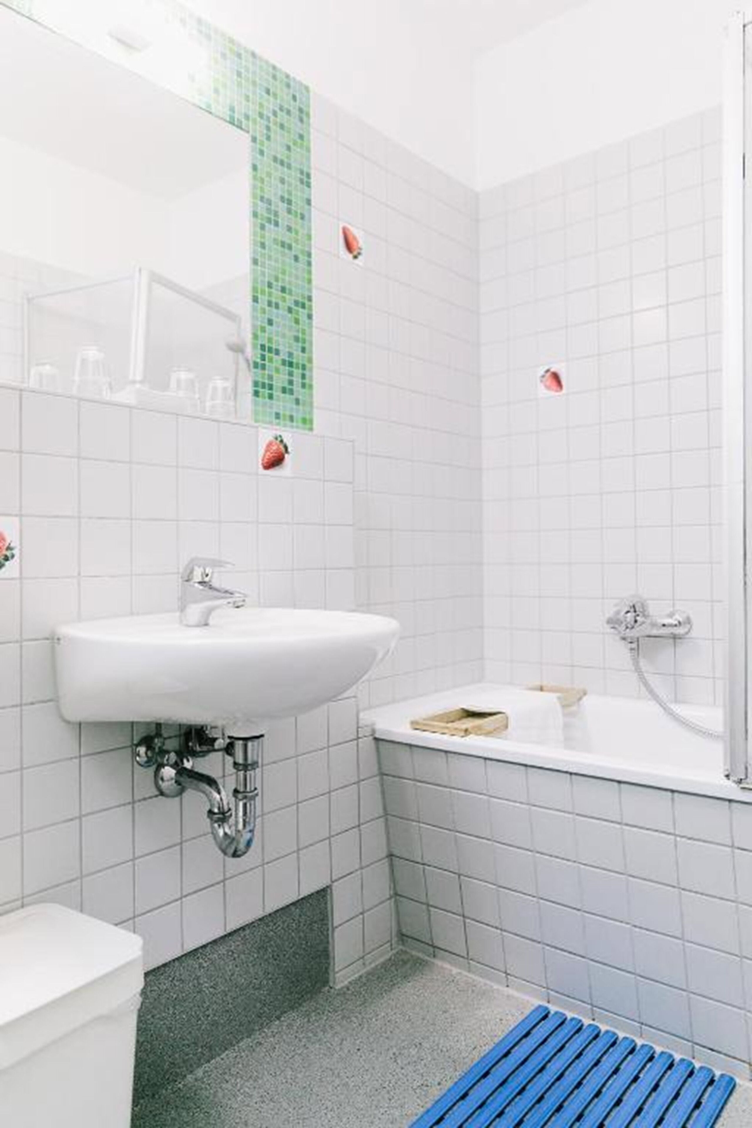 Un baño con lavamanos blanco, bañera y ducha.