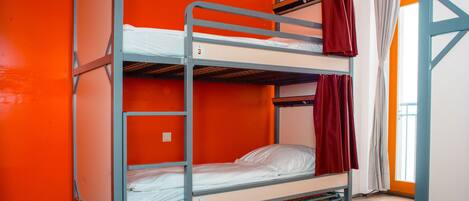 Un lit superposé avec un lit inférieur, un matelas et un oreiller.