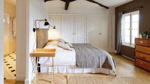 Une chambre à coucher avec un lit en bois, un bureau, une lampe et une commode.
