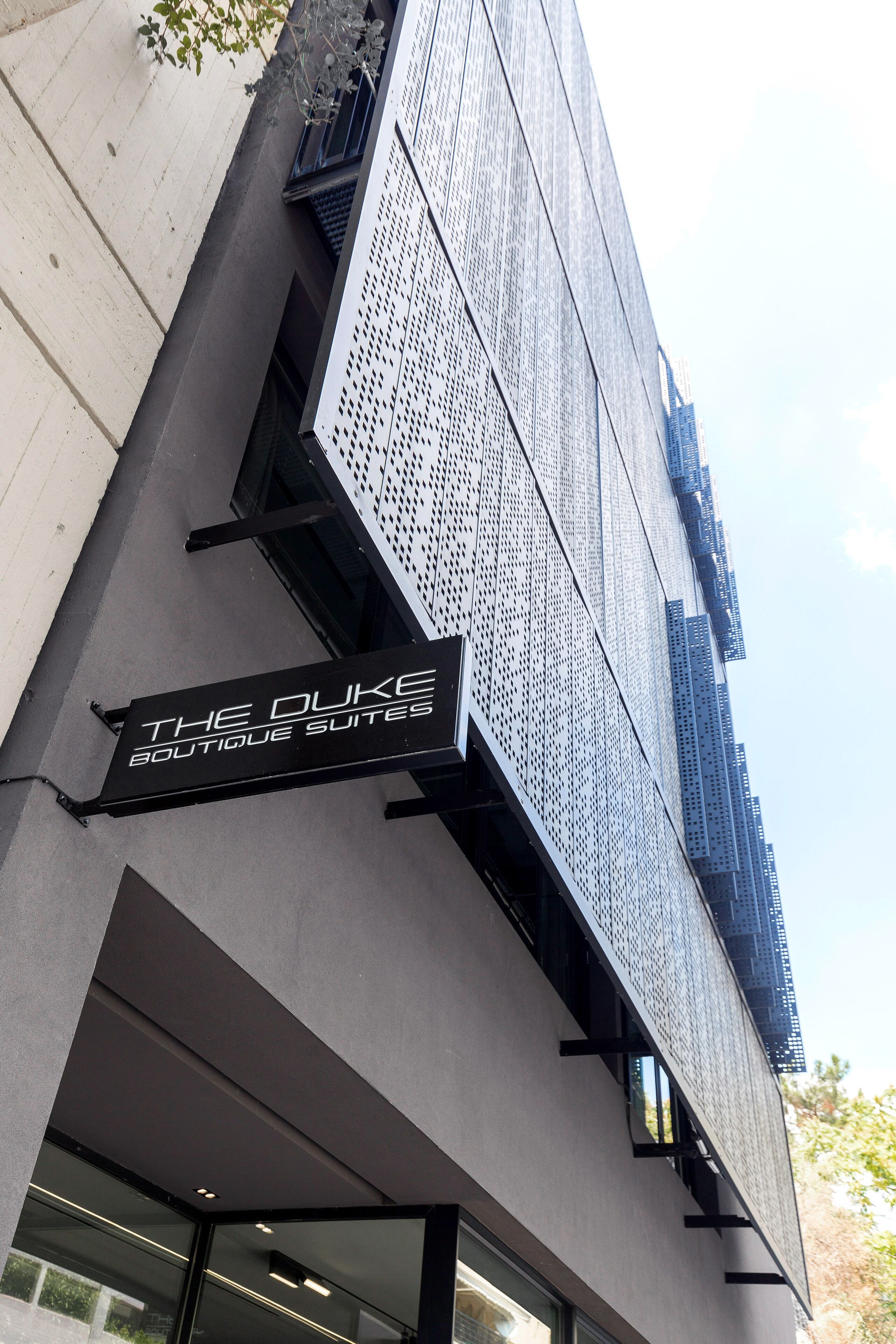 Fachada de un edificio con un letrero que dice "The Duke Boutique Suites".