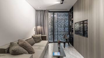 A modern living room with a sofa, a coffee table, and a TV mounted on the wall.