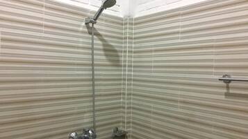 A shower with a handheld showerhead and a wall-mounted faucet.