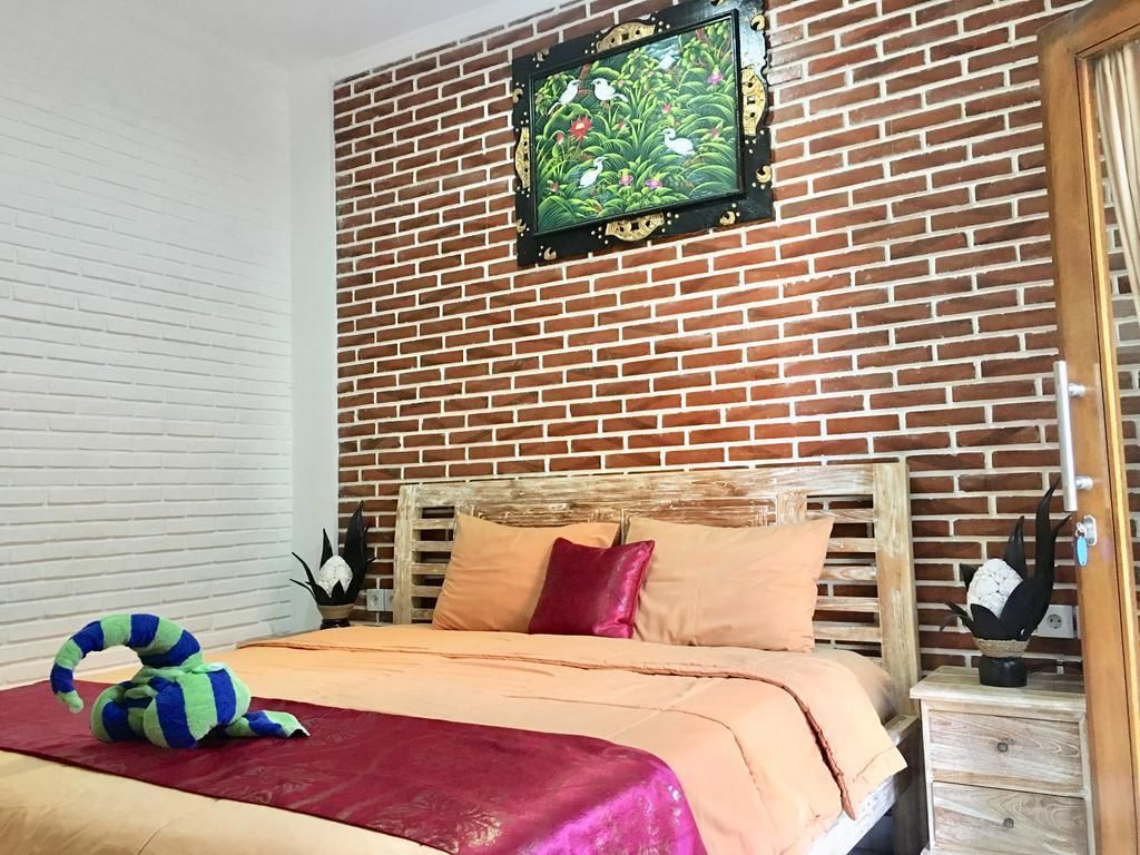A bedroom with a brick wall, a bed with a wooden headboard, and a decorative wall hanging.