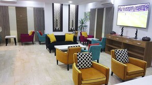 Una sala de estar moderna con sofás, sillones y un televisor.