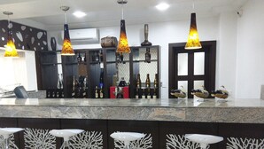 Una cocina moderna con encimera de mármol, lámparas colgantes y una vinoteca.