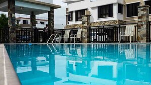 A swimming pool with lounge chairs and a covered area. - Tumon Belair (Tamuning)