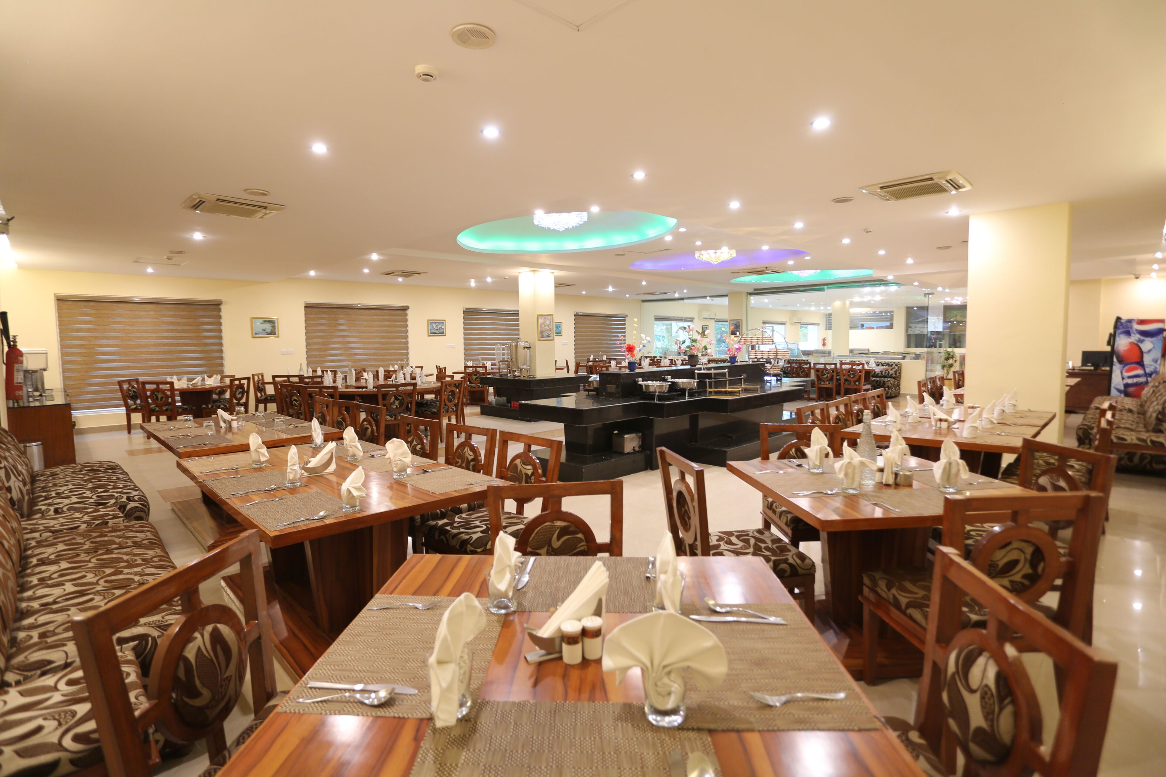 Um restaurante amplo com várias mesas e cabines, equipado com amenidades básicas como guardanapos e talheres.