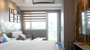 Ein modernes Schlafzimmer mit einem großen Bett, einer Couch, einem kleinen Tisch und einem Fernseher.