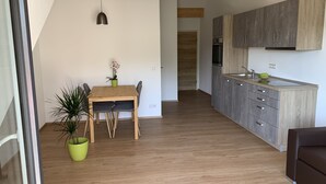 A modern kitchen with grey cabinets and a wooden ceiling. - Silvia’s Apartment 2 with a lake view (Goldbach)