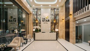A hotel reception area with a marble counter, comfortable seating, and modern decor. - K-Zone The Star Hotel (Hai Phong)