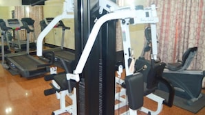 Une salle de sport équipée de tapis de course, de vélos elliptiques et de matériel de musculation.