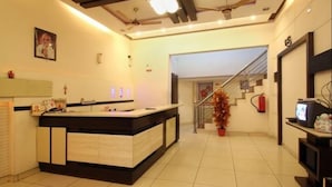 Un moderno vestíbulo de hotel con una recepción, una escalera y un extintor.