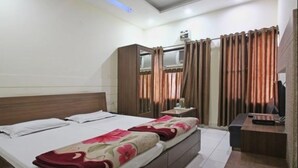Un dormitorio con cama, escritorio y cortinas.
