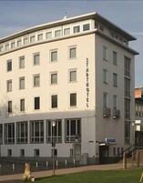 A multi-story building with a flat facade, large windows, and a sign reading "STADTHOFEL".