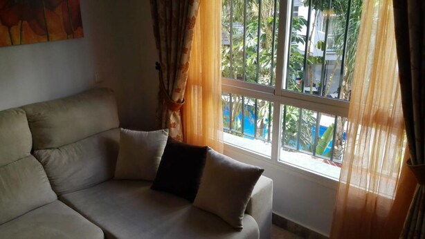 A room with a sofa and a window with curtains. - Apartment in La Carihuela, Wifi & 20 meters from the beach (Torremolinos)