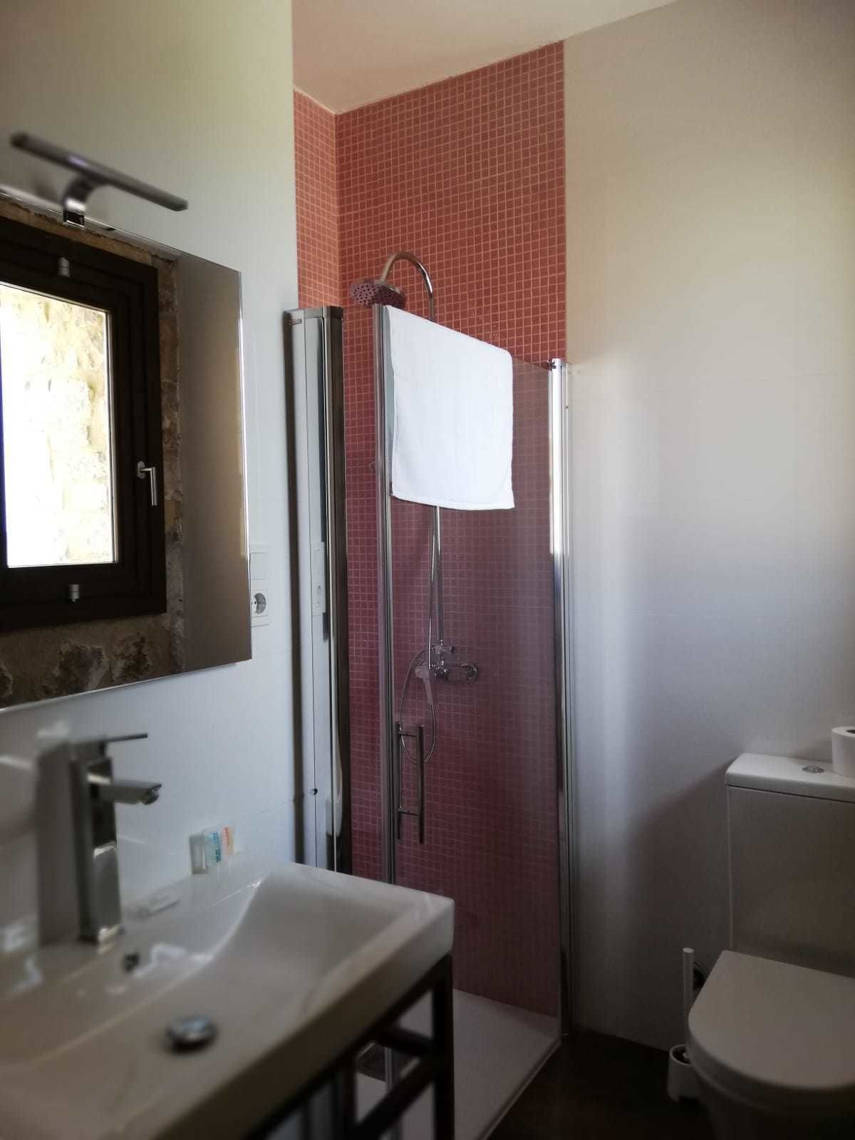 A bathroom with a shower, sink, and toilet.