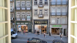 Vista de una calle con edificios, incluyendo una tienda 'PARFOIS' y una tienda 'CALZEDONIA'.