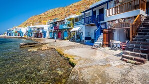 A coastal building with multiple balconies, a stone staircase, and a clear view of the sea. - Neosikos AmazingBeach House Milos Island (Milos)