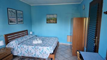 Un dormitorio con cama, un armario de madera, una mesita de noche y una pequeña mesa.