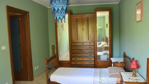 A bedroom with a bed, a dresser, a mirror, and a nightstand. - Casa Omnia B&B (Castellamonte)