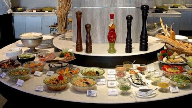 Um buffet com diversos alimentos e acompanhamentos.