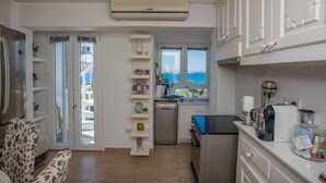 A compact kitchen with white cabinets, a dishwasher, and a coffee maker. - Beautiful Apartment With Amazing View In Mykonos Old Town (Mykonos)
