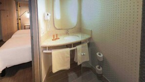 A hotel room with a bed, a bathroom with a sink, mirror, towel rack, and toilet. - ibis Juazeiro do Norte (Juazeiro do Norte)