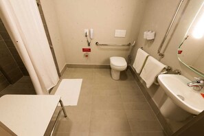 Une petite salle de bain propre, équipée de toilettes, d’un lavabo et d’une douche.