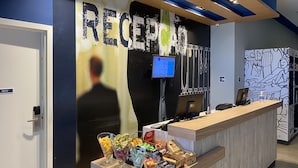 Et receptionsområde med en disk, en computerskærm og en væg med et stort 'RECEPTION' skilt.