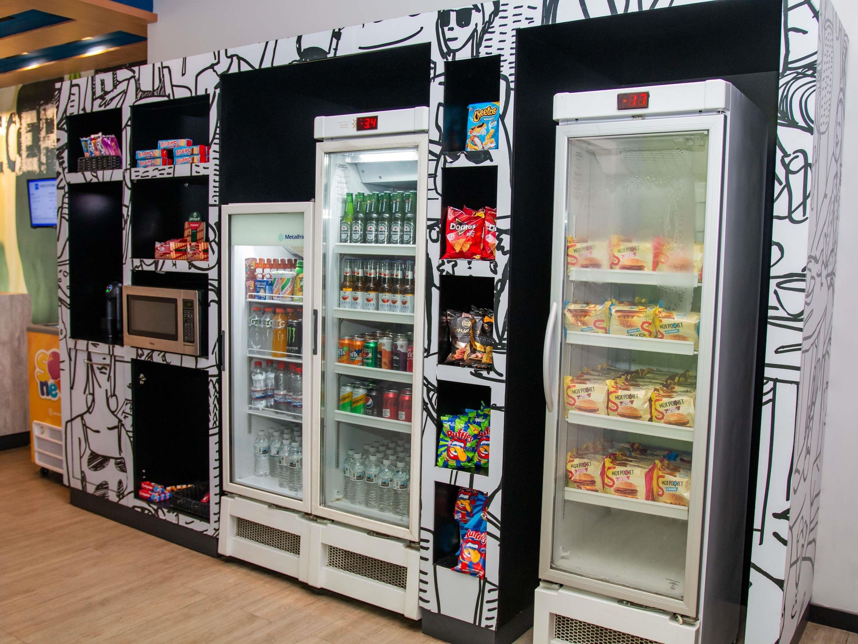Vending machines with various snacks and drinks, a microwave, and a digital clock.