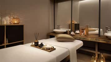 Relax in a serene spa room with a large mirror, vanity, and massage table.