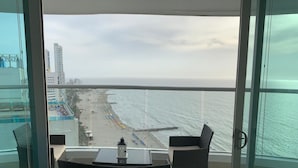 En balkon med udsigt over strand og hav.