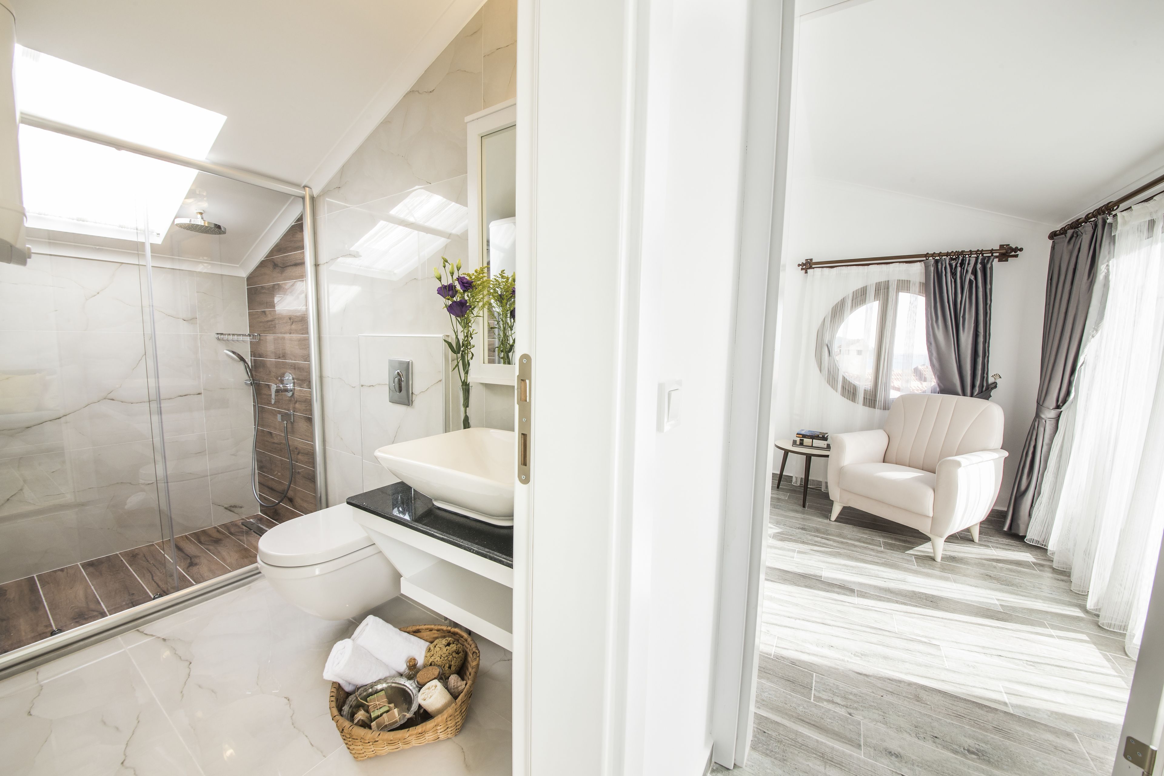 Une salle de bain moderne dotée d’une douche à parois de verre, d’une baignoire sur pieds et d’un meuble-lavabo avec un grand miroir.