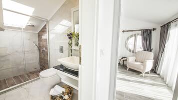 Une salle de bain moderne dotée d’une douche à parois de verre, d’une baignoire sur pieds et d’un meuble-lavabo avec un grand miroir.