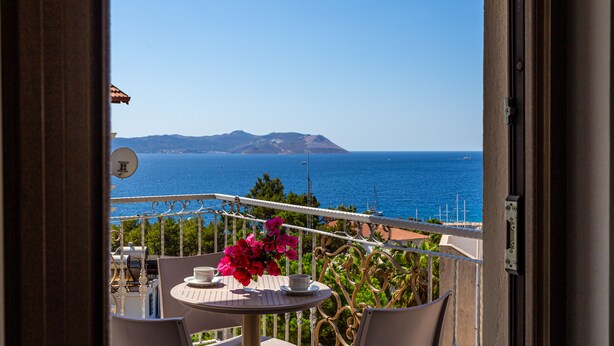 A balcony with a table, chairs, and a view of the sea. - Cedrus Suites (Kas)