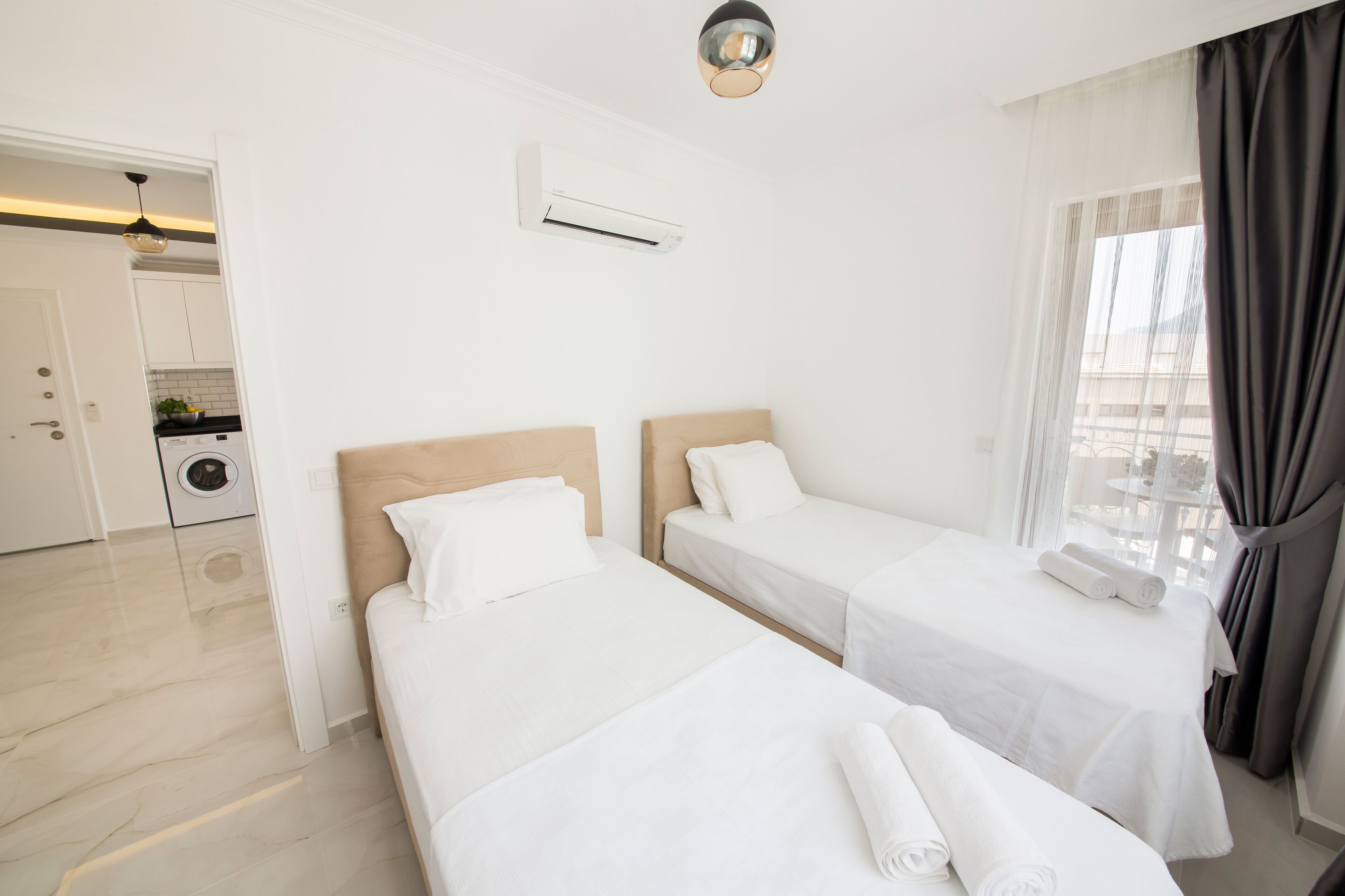 Een hotelkamer met twee eenpersoonsbedden, een badkamer en uitzicht op de stad.