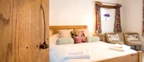 Quarto com estrutura de cama de madeira, cabeceira e mesa de cabeceira com abajur.