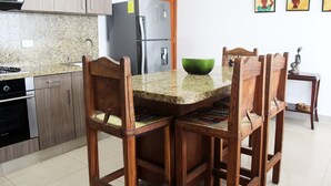 Eine Küche mit Granit-Arbeitsplatten, Holzkästen, einem Edelstahl-Kühlschrank und einer grünen Schüssel auf der Arbeitsfläche.