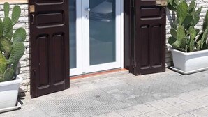 A building entrance with a glass door, two potted cacti, and a sign for 'Ca'azebo Rooms'. - Gazebo Rooms (Margherita di Savoia)