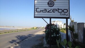 A sign for Gazebo Bay with a clear view of the road and surrounding landscape. - Gazebo Rooms (Margherita di Savoia)