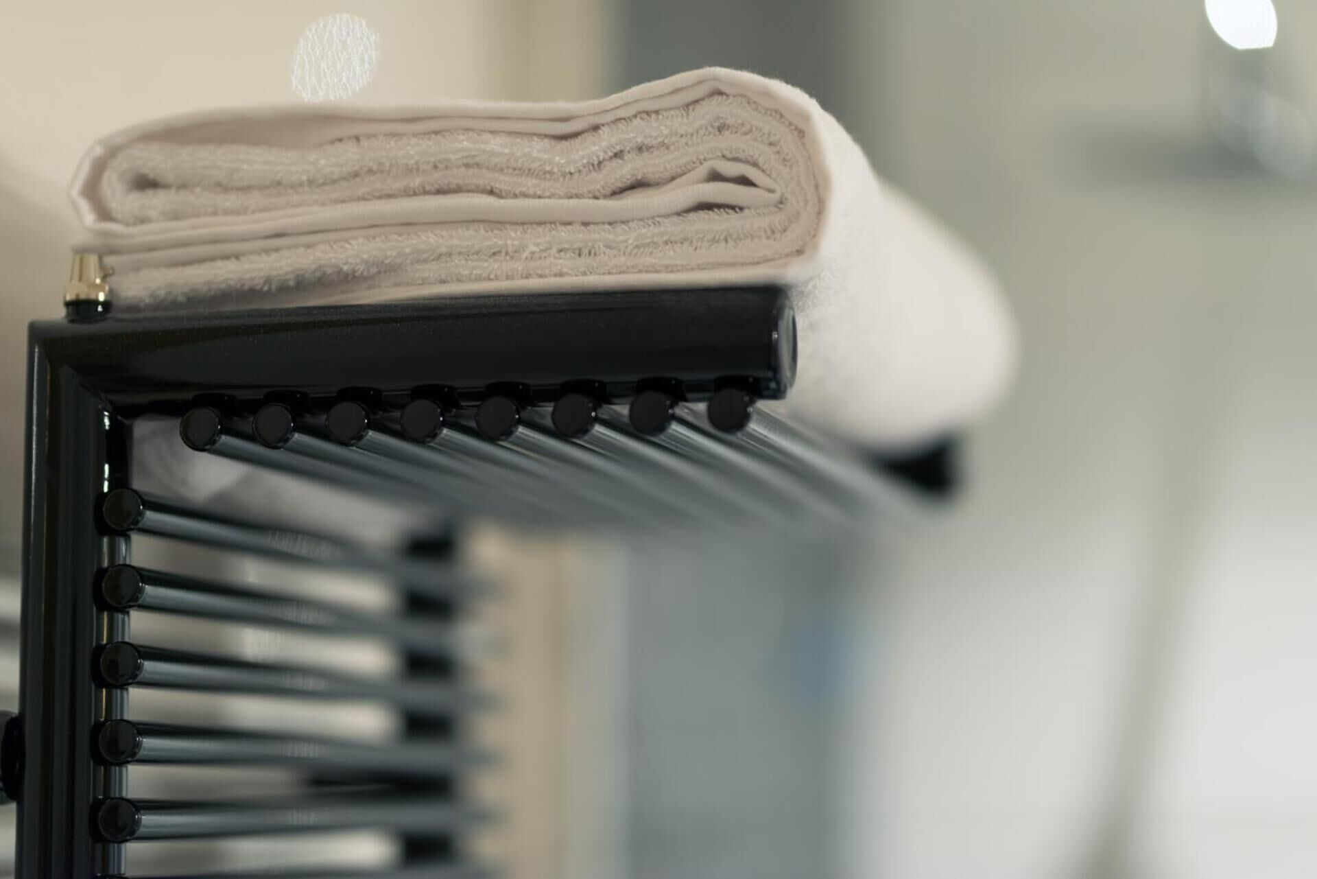 A folded towel on a black rack.
