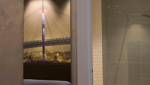 A hotel room with a bed, a shower, and a mural of a bridge. - Le Mie Città (Pescara)