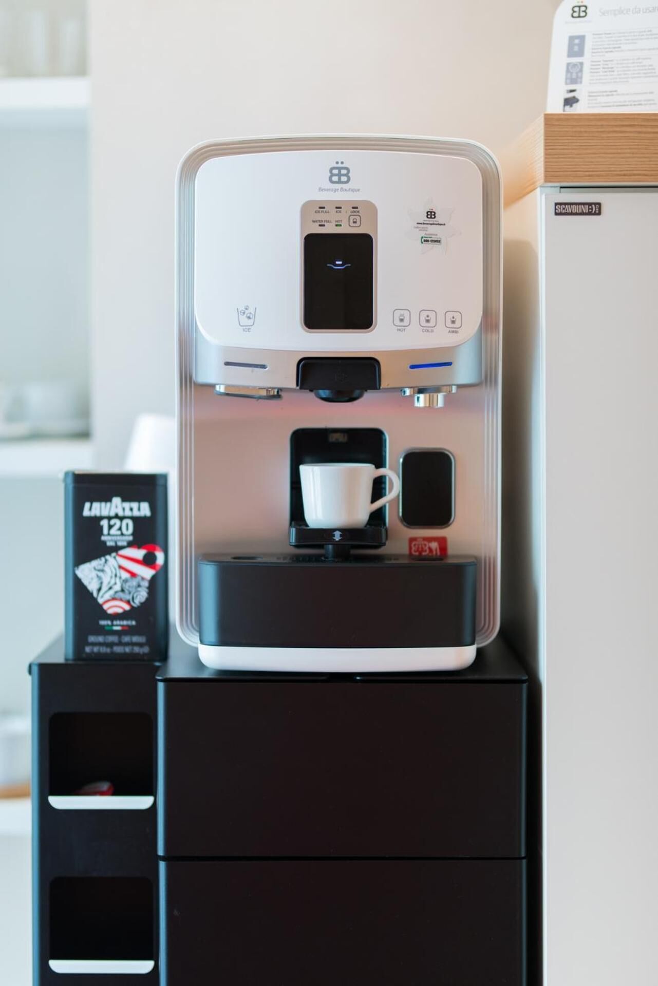 A coffee machine with a cup holder and a coffee pod dispenser.